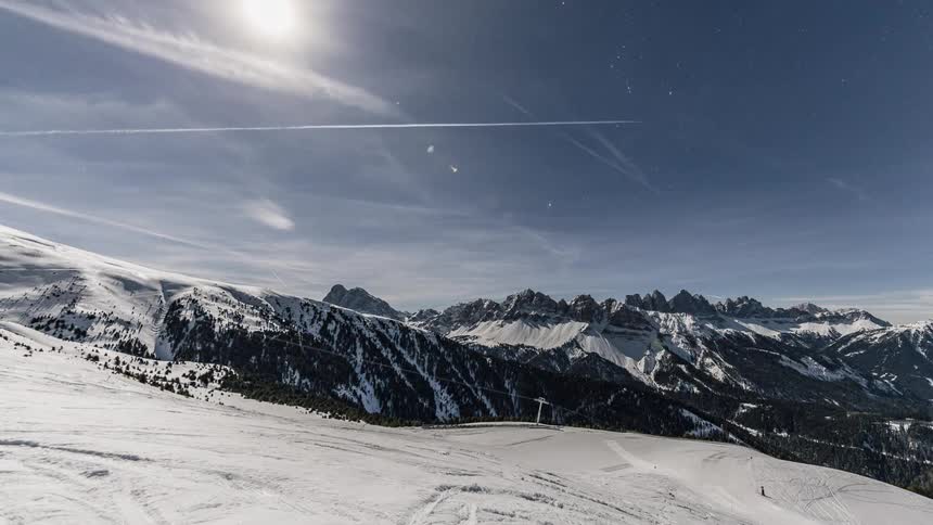 Clouds pass above a snow covered mountain