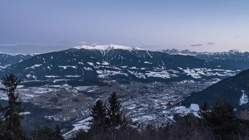 A busy city at the foot of snow tipped mountains