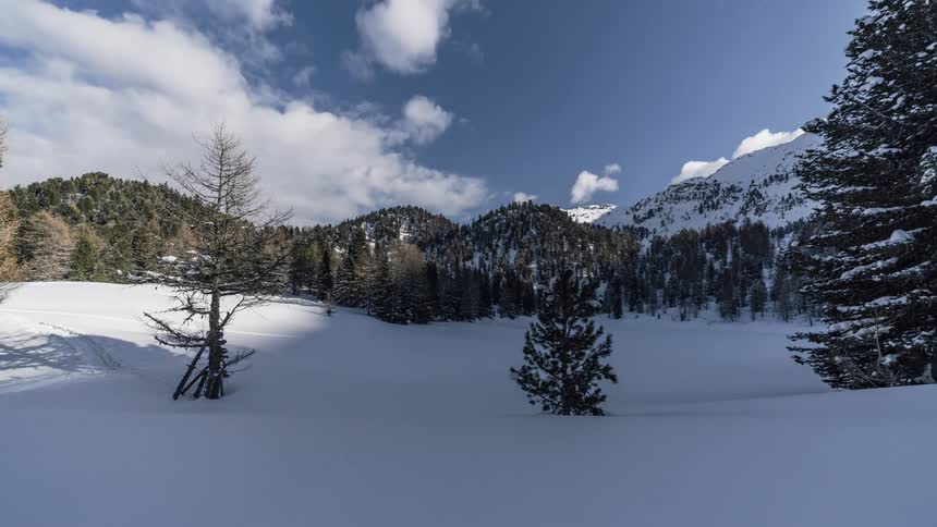 White clouds float over a snow covered field