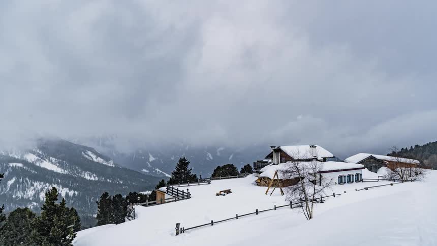 Clouds float over snow covered buildings