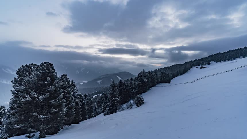 Clouds pass above a snowy mountain