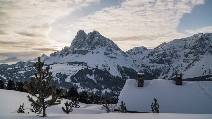 Clouds pass over a snowy mountain