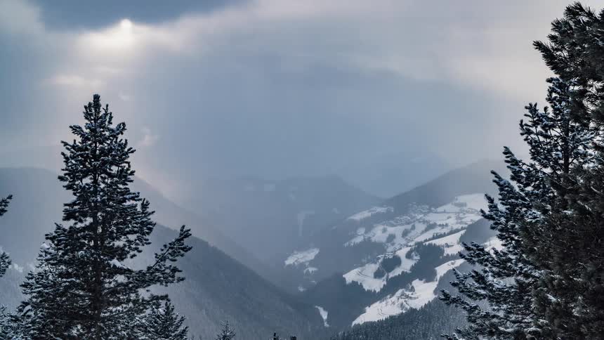Clouds float above snowy mountains