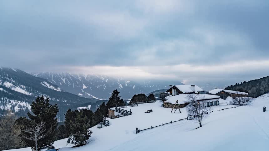 Clouds pass over a mountain cabin