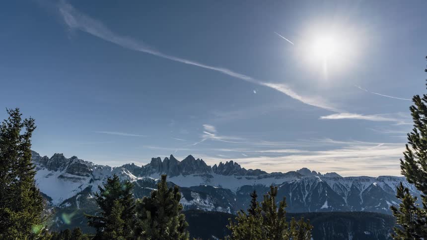 Clouds pass above a snowy mountain