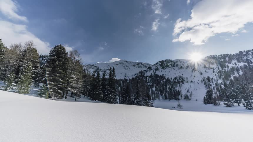 Clouds pass over a snowy mountain