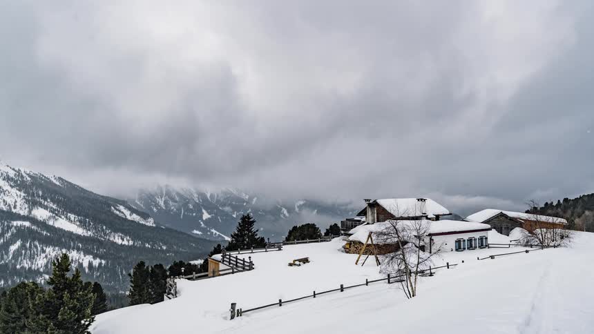 Clouds pass above a mountain cabin