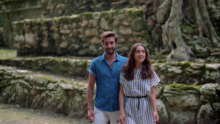 Man and woman walk near a line of rocks