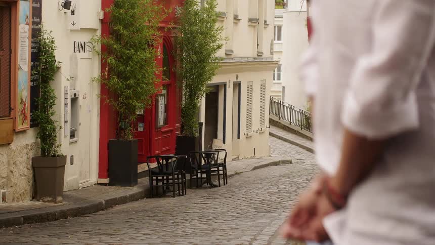 People walk across a cobblestone street