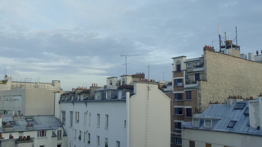 Clouds float above city buildings