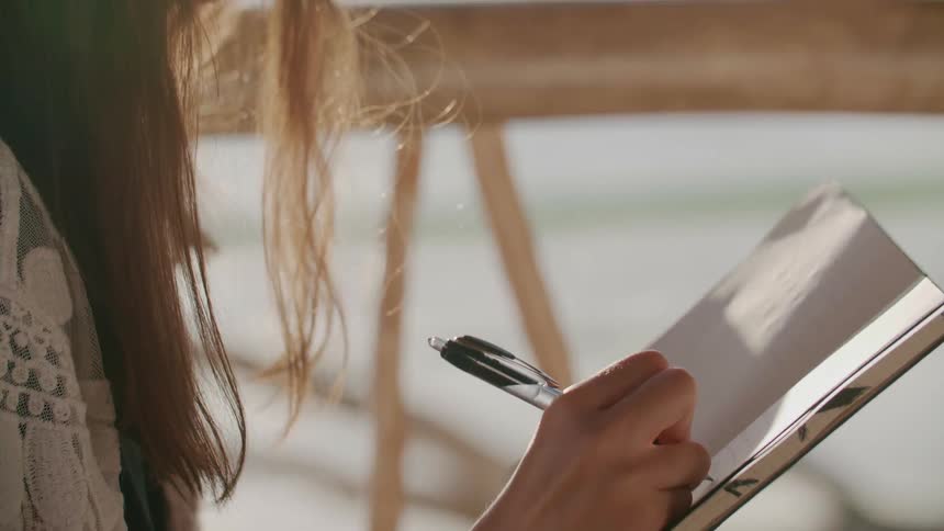 A woman writes in a notebook
