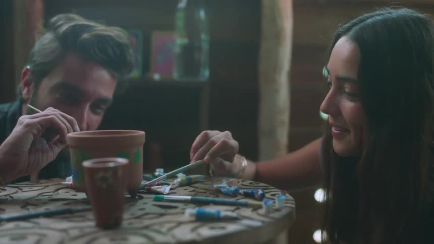 Man and woman paint a piece of pottery