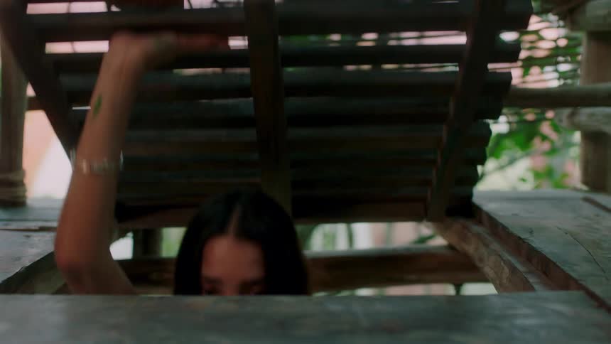 A woman opens the trap door of a tree house