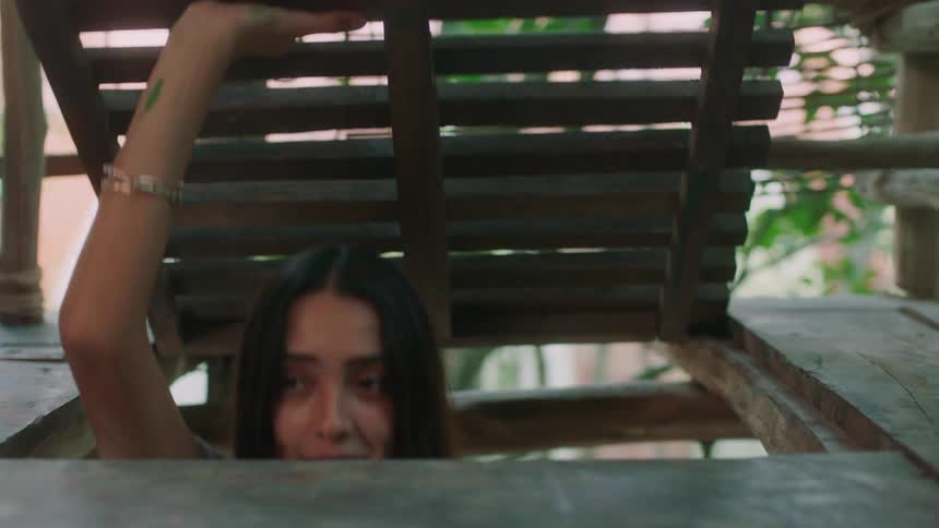 A woman enters a tree house through the floor