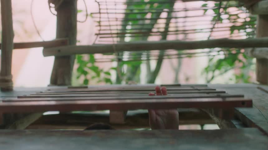 A woman closes the trap door of a tree house