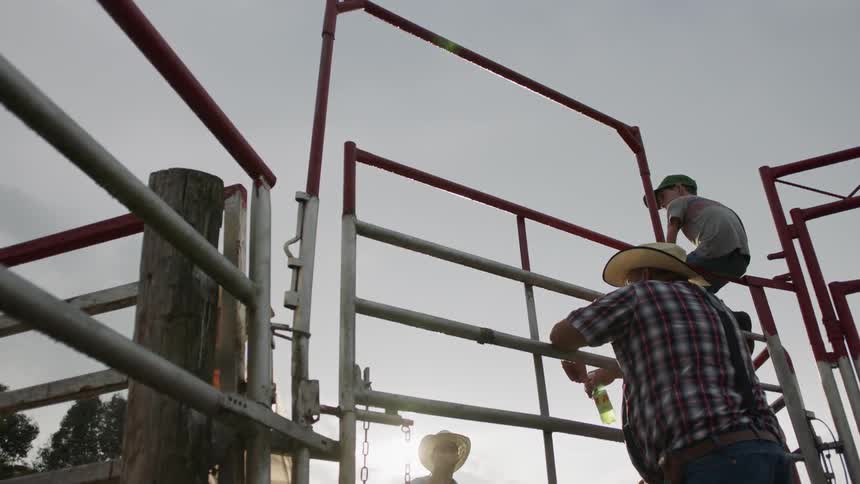 Cowboys stands next to a gate