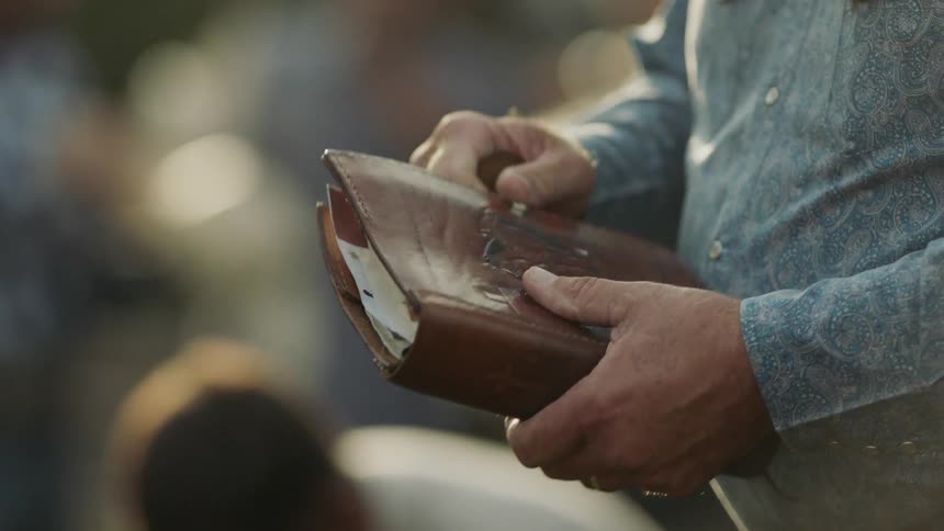 A man holds a leather bound book