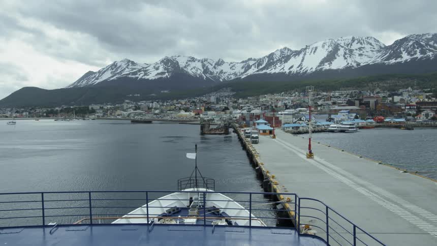 A ship is moored in harbor to a dock