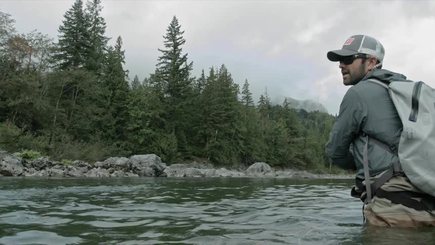 A man fly fishes in a stream