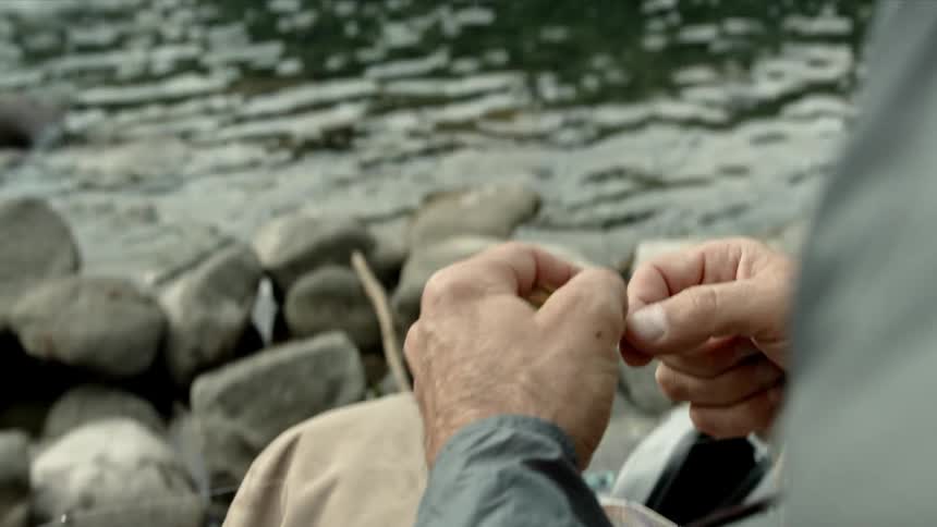 A fisherman ties a fishing line