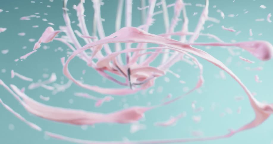 Pink batter flies off a mixer beater
