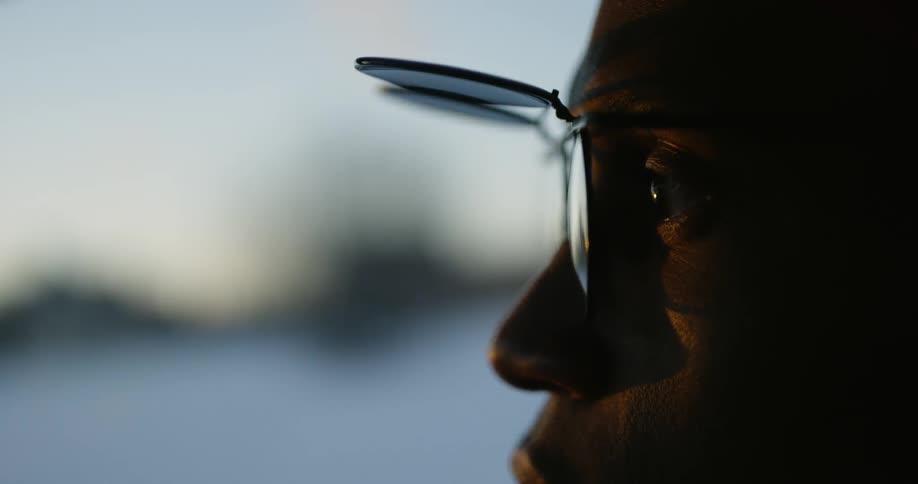 A man with flip up glasses looks around
