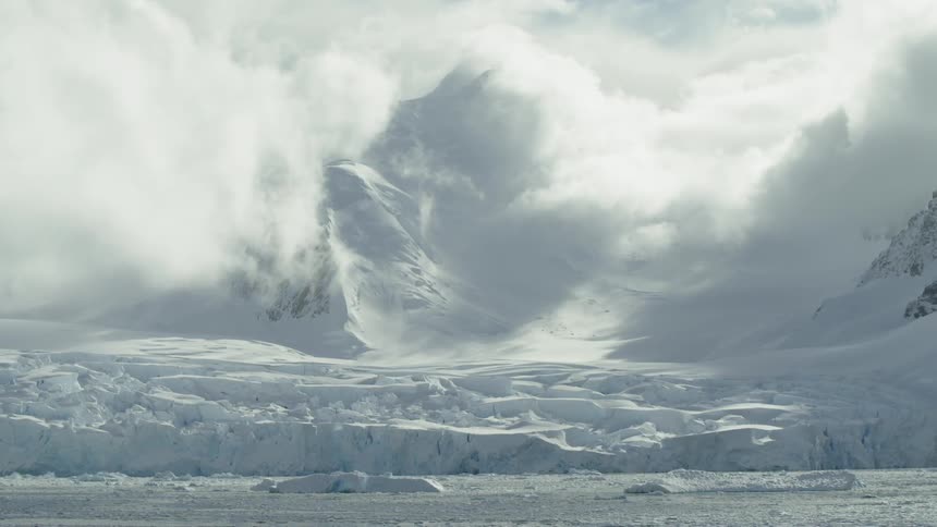 Clouds hang above a frozen mountain and sea