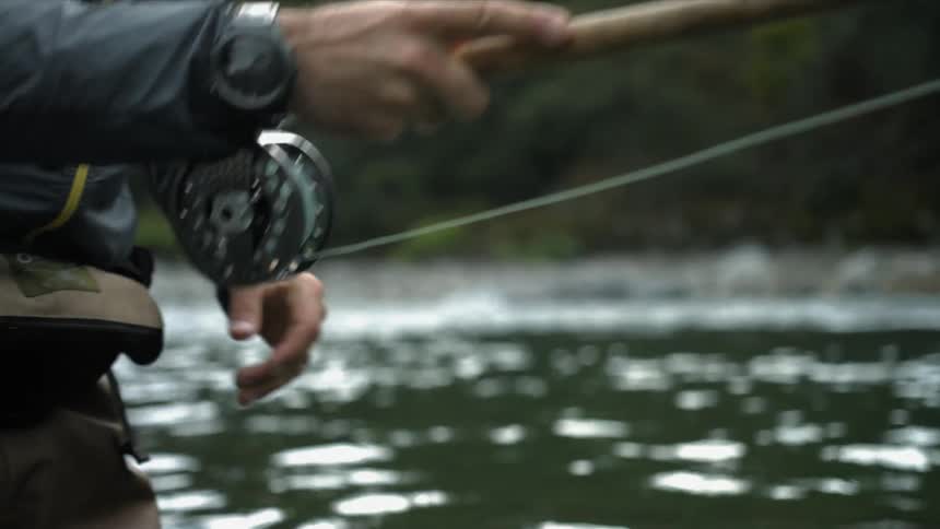 A fisherman casts a fishing line in a river