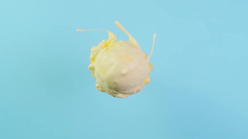 A scoop of ice cream is spinning in a circle throwing off streams of cream