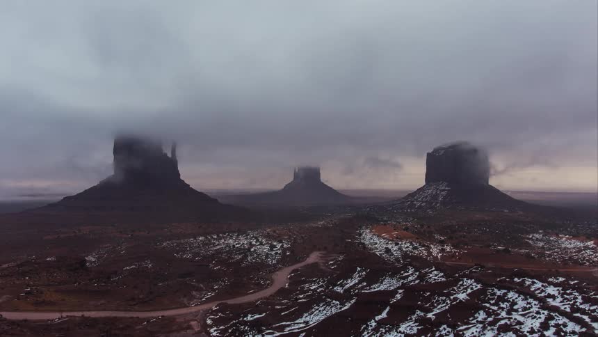 Clouds float over rock formations in the desert