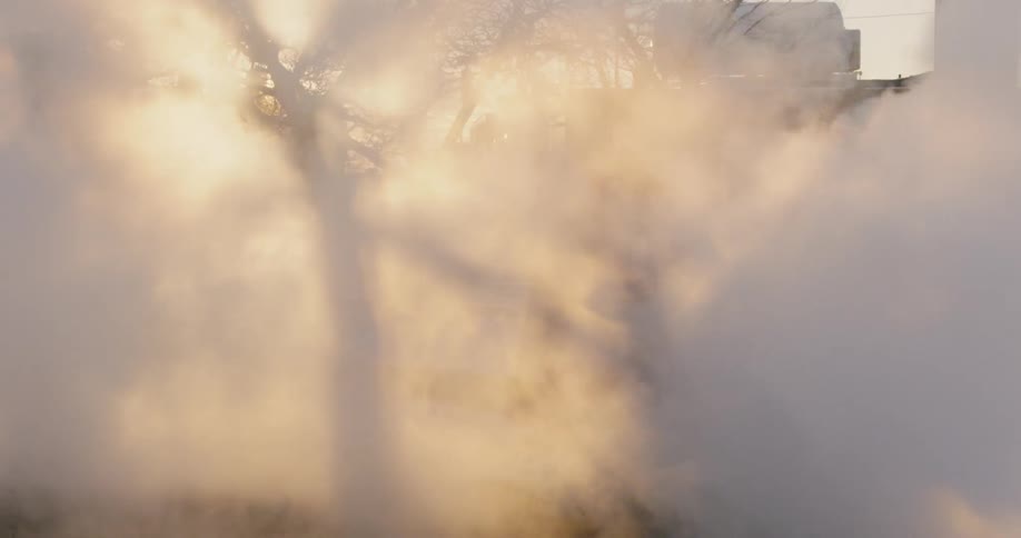 Smoke billows as a man in a toque dances