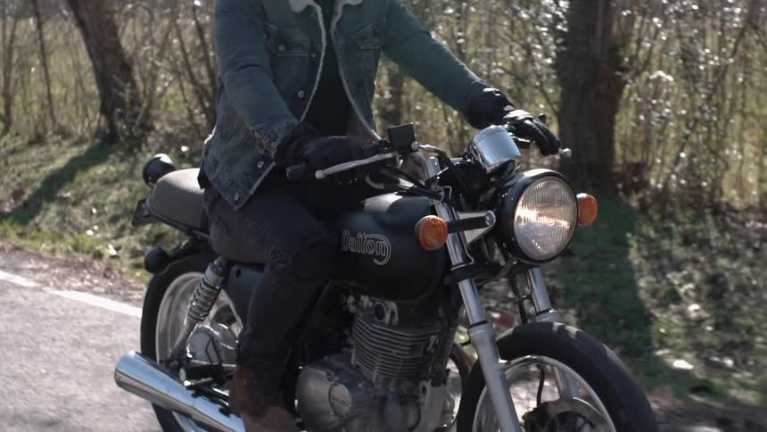 A motorcyclist rides down a road