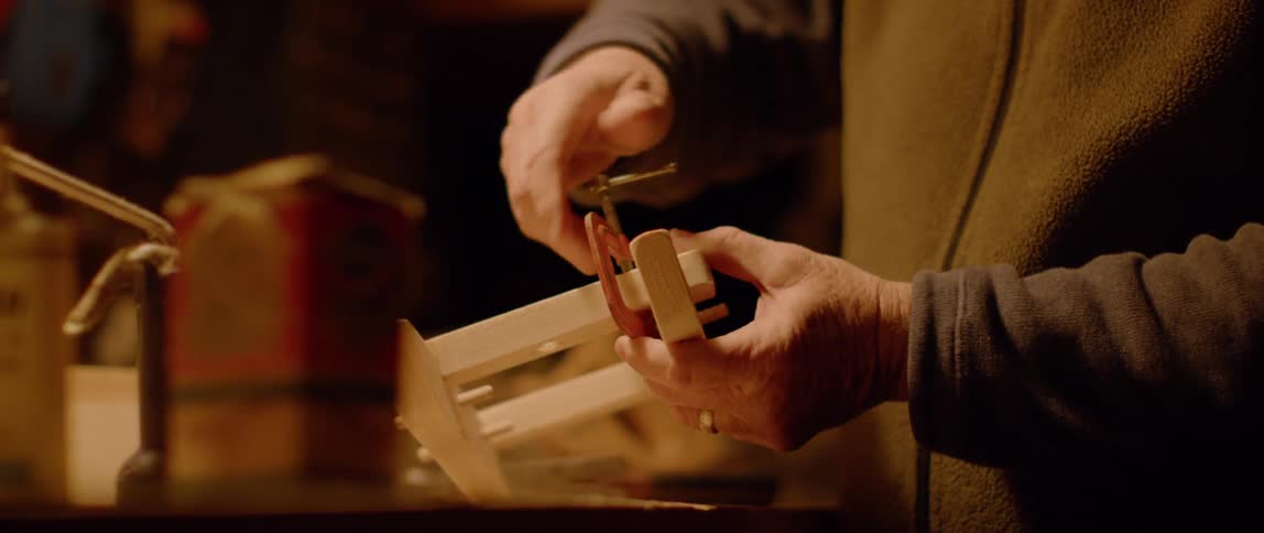 A man adjusts a vise on a piece of wood