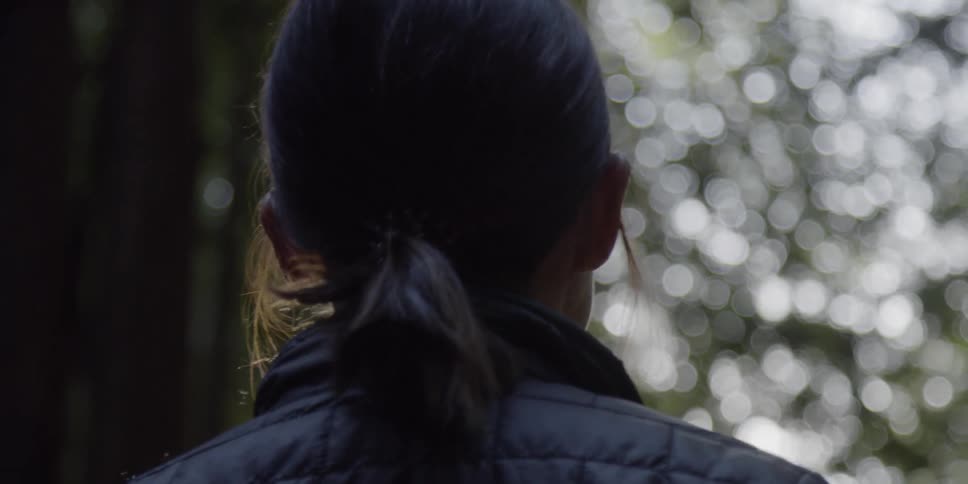 Woman in a ponytail looks at the trees