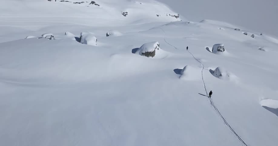 Skiers glide down a snowy mountainside