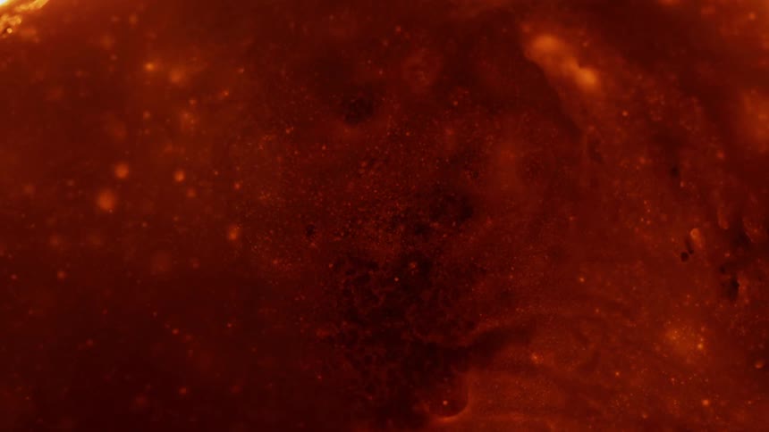 A red fluid bubbles and oozes