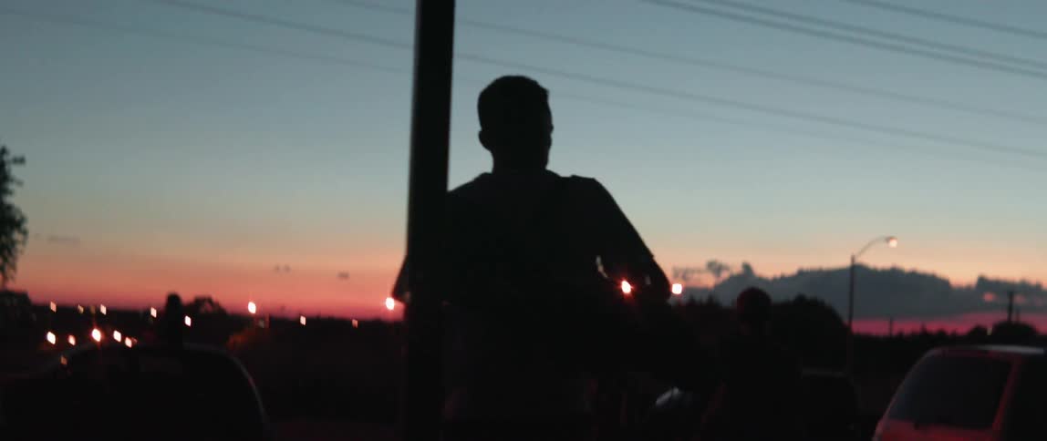 A man walks outside at dusk