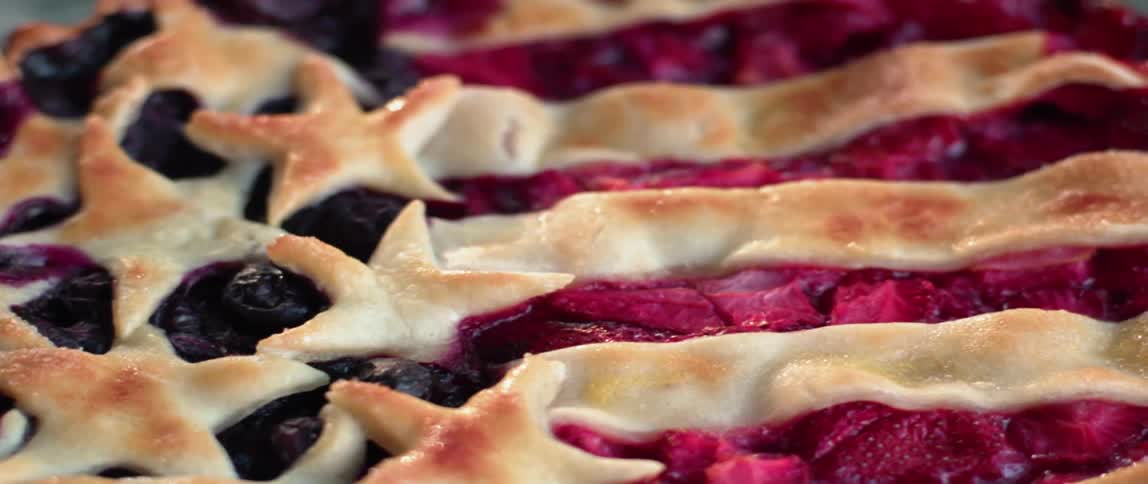 The crust on a berry pie is displaying a stars and stripes pattern