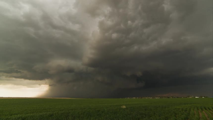 Storms clouds over a small farming community form a tornado