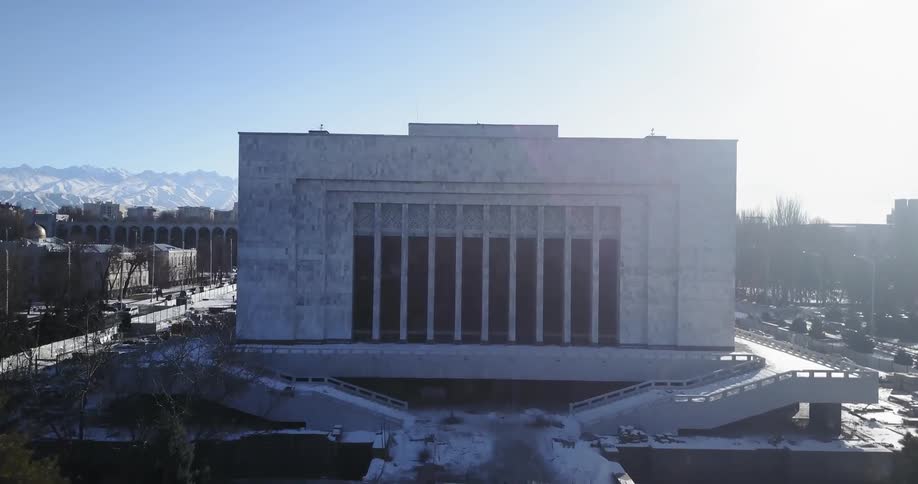 A monument statue is displayed by a building