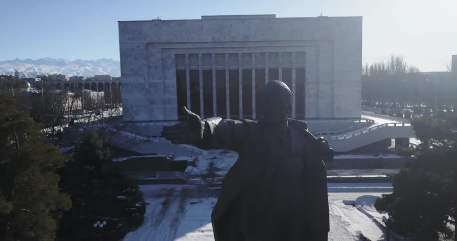 A tall statue of a man is near the building