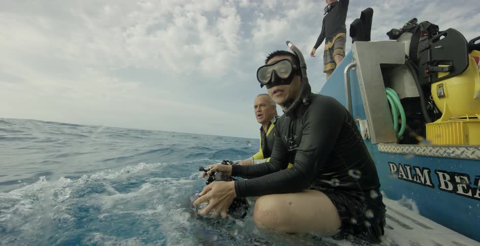 Divers ride on the back of a boat