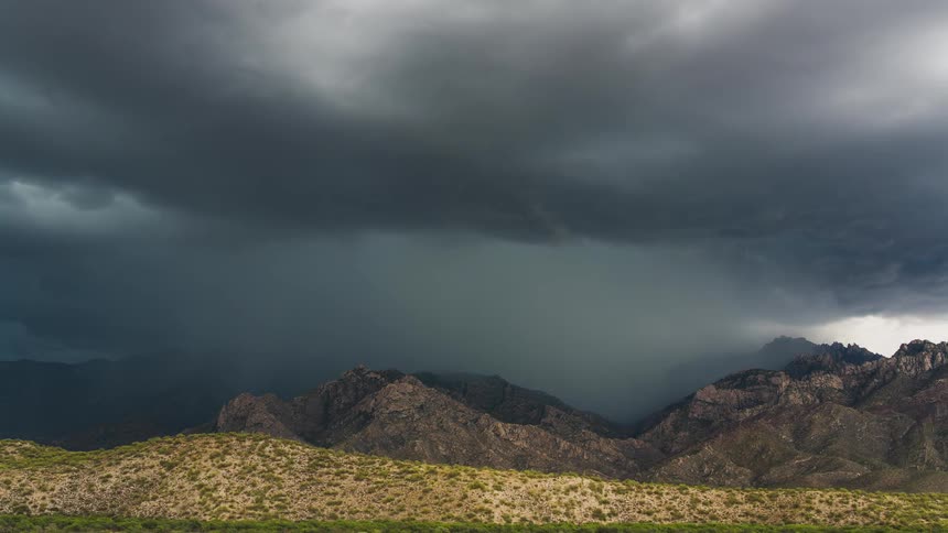 Clouds dumping rain over a mountain