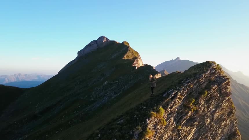 A person walks down the mountain top
