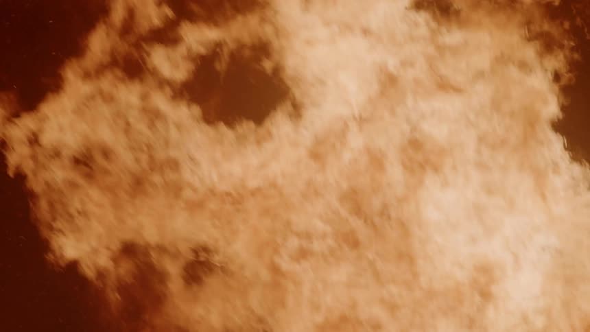 Flames rise in a night sky