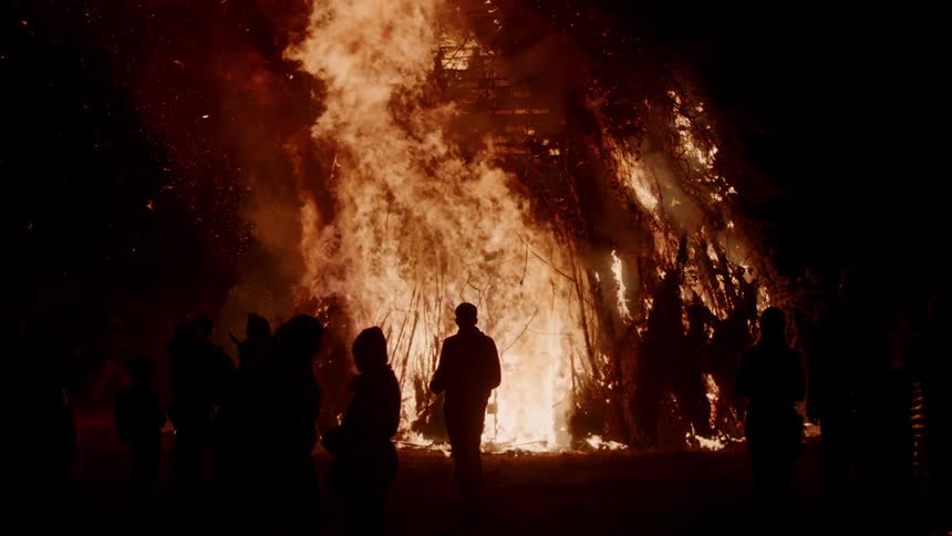 People walk away from a huge fire at night