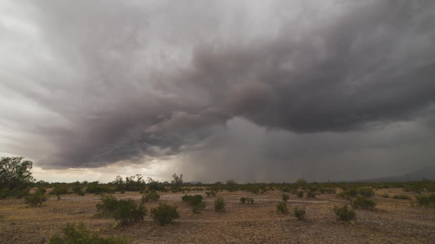 Time lapse of a field with large storm clouds forming up ahead