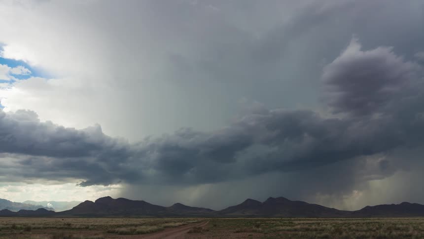 Time lapse of some clouds forming a heavy storm up ahead by mountains