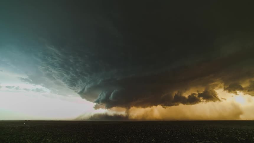 Tornado, supercell, dust and lightning sweeping across a corn field