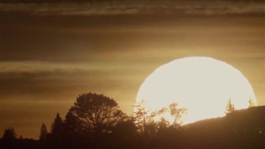The sun completely sets behind the hills